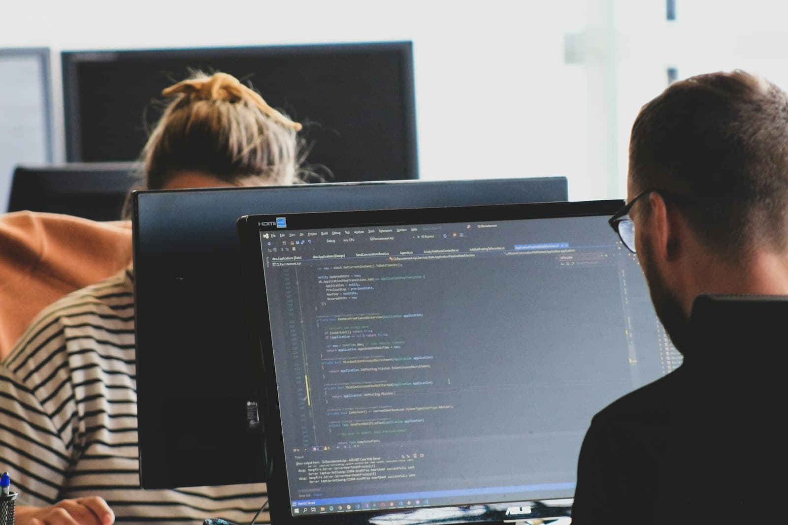 Two engineers reviewing test code at their monitors
